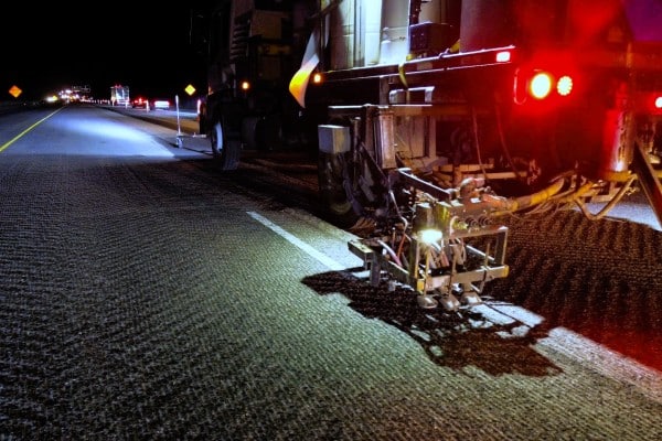 Ozark Striping truck applying reflective pavement markings during nighttime highway striping operations for enhanced road visibility and safety