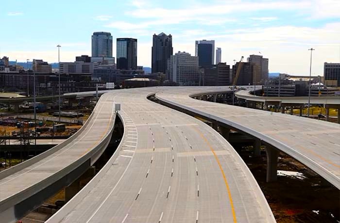 Elevated highways striped by Ozark Striping Co. LLC leading towards a city skyline with skyscrapers